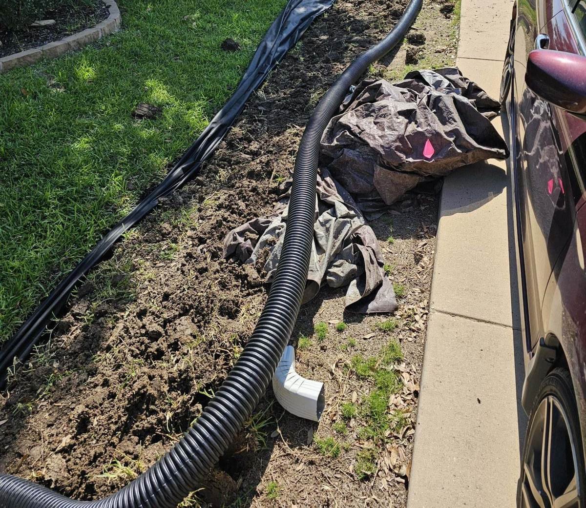 French drain discharge outlet daylighting toward the street