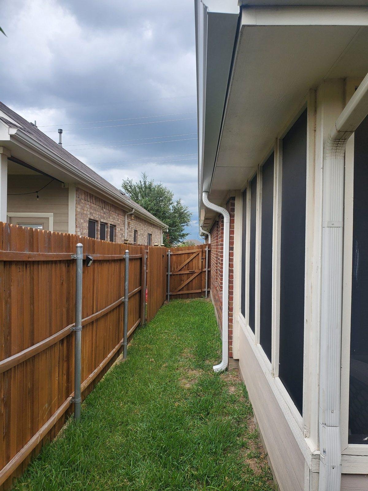 Side yard downspout and drainage path on a Texas home