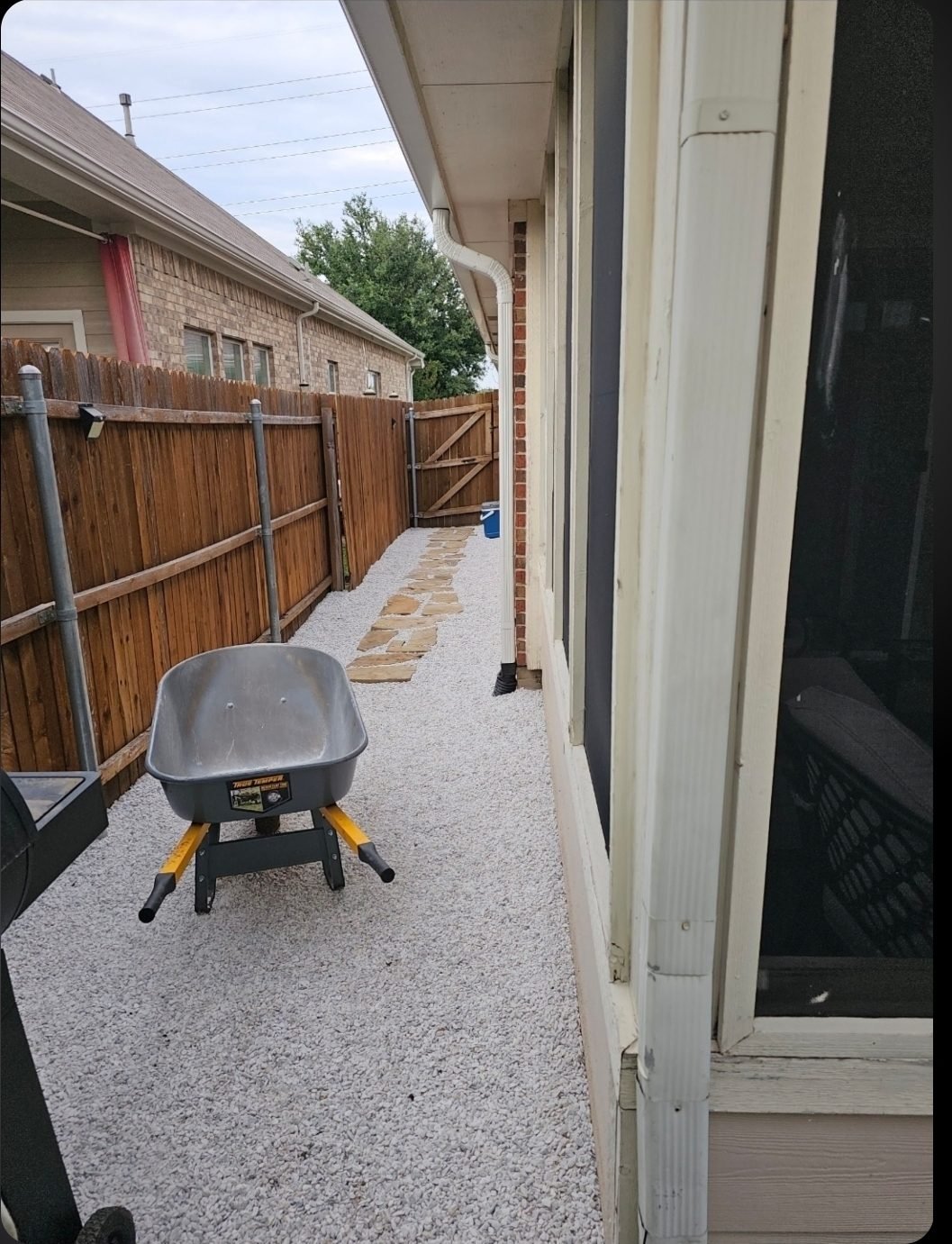 Compacted decomposed granite base laid over a new French drain in a side yard